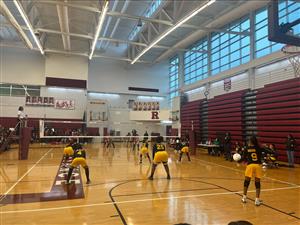 Girls volleyball team serving a ball